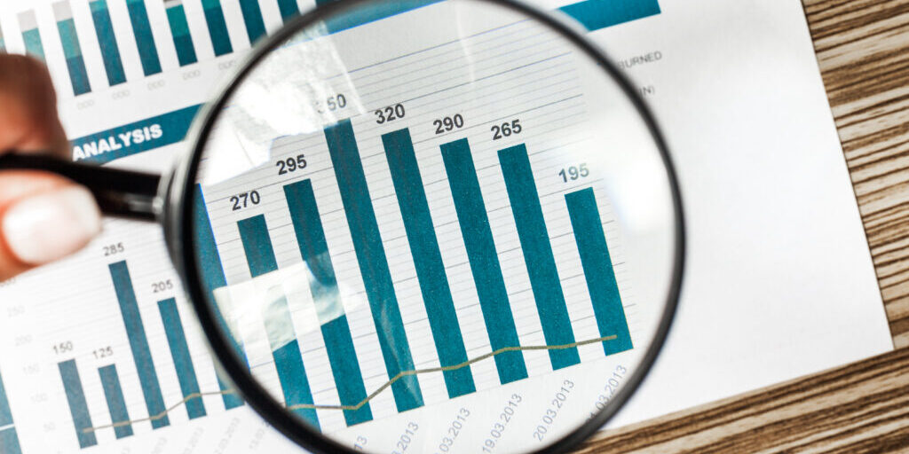 Magnifying glass and business growth graph